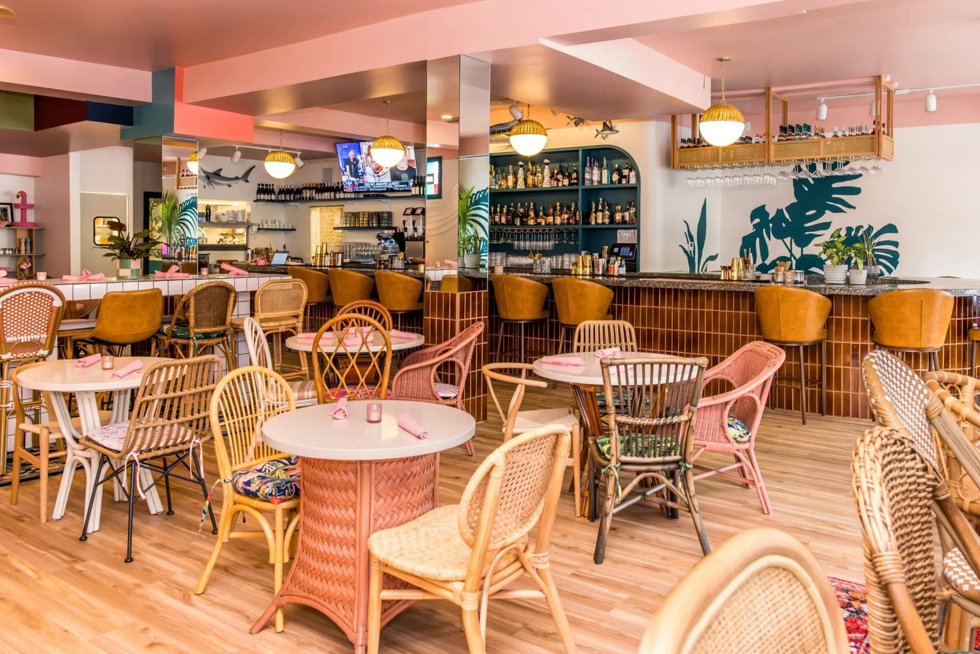 Inside Flamingo Drive — tropical pink bar and rattan dining room
